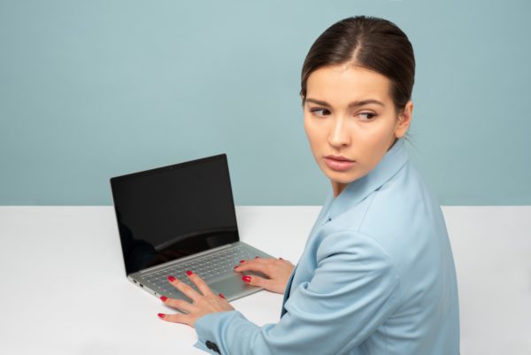 A Puzzled Woman Looking Away From A Computer 